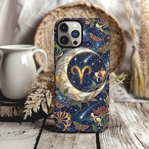 May include: A smartphone case featuring a dark blue background with a stained-glass style design. The pattern includes a large crescent moon, the golden Aries zodiac symbol, scattered stars, shooting stars, colorful flowers, and small butterflies.