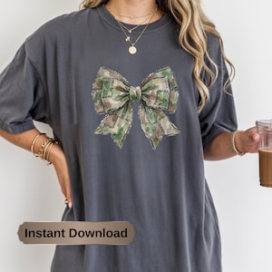 Könnte beinhalten: Dunkelgraues T-Shirt mit einem Aquarell-Schleifendesign in Grün-, Braun- und Tan-Camouflage. Das Shirt hat eine lockere Passform. Der Text "Instant Download" wird auf einem braunen Banner unten angezeigt.