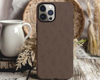 Könnte beinhalten: Eine braune Smartphone-Hülle mit einem dezenten, sich wiederholenden Linienmuster aus zarten Wildblumen und Blättern. Die Hülle verfügt über einen rechteckigen Ausschnitt für das Kameramodul, das drei kreisförmige Linsen und einen Blitz enthält.