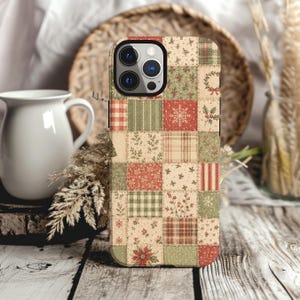Könnte beinhalten: Eine Smartphone-Hülle mit Patchwork-Design und verschiedenen weihnachtlichen Mustern in Rot-, Grün- und Cremetönen. Das Raster enthält Motive von Schneeflocken, Stechpalmenbeeren, Weihnachtssternen, Karos und Vichy-Karos.