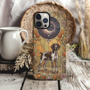 May include: A smartphone case featuring a brown and white German Shorthaired Pointer standing in a stained glass window frame. The design includes a crescent moon, stars, autumn leaves, pumpkins, and chrysanthemums in shades of orange and gold.