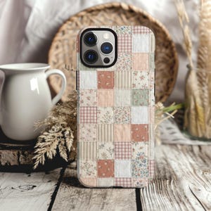 May include: A smartphone case featuring a patchwork design of various fabric squares in soft pastel tones. The pattern includes small floral prints, gingham checks, and thin vertical stripes in shades of pink, sage green, cream, and white.