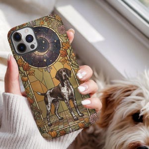 May include: A smartphone case featuring a stained glass style illustration of a brown and white spotted dog. The design includes a dark celestial moon and star background, autumn leaves, and orange pumpkins in a decorative frame.
