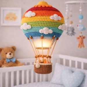 Puede incluir: Lámpara de globo aerostático de ganchillo hecha a mano, ideal para una habitación infantil. El globo tiene rayas de arcoíris con detalles de nubes blancas y una cesta marrón. La lámpara cuelga del techo, proporcionando una luz suave.