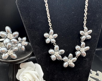 Colar e pulseira vintage em tom de chumbo com pingente de flor de pera artificial e fecho.