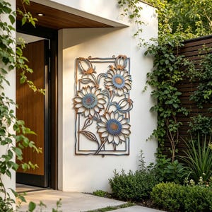 May include: A metal wall art piece featuring a sunflower design. The artwork has a rectangular frame with blue and brown tones. The sunflowers have blue petals and brown centers. The piece is mounted on a white wall, with greenery surrounding it.