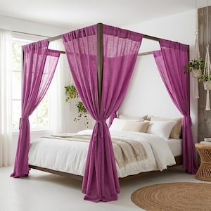 Puede incluir: Una cama con dosel que presenta postes de madera oscura y está drapeada con cortinas de color magenta vibrante. La cama está vestida con ropa de cama blanca y una manta beige. Las cortinas están atadas a los postes, creando un efecto de dosel.
