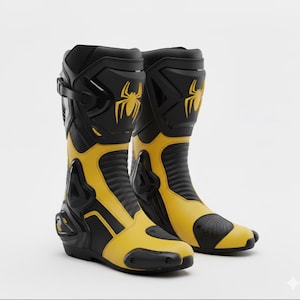 May include: A pair of black and yellow motorcycle boots. The boots have a tall design with a prominent yellow spider logo on the upper shaft. The boots feature a combination of black and yellow panels, with reinforced areas for protection. The boots are designed for motorcycle riding.