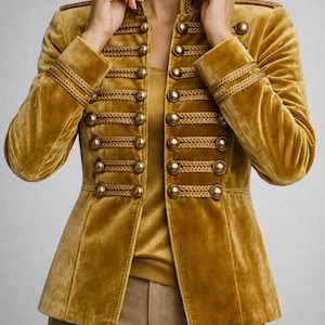 May include: Mustard yellow velvet jacket with gold-colored buttons and decorative trim. The jacket features a high collar and a tailored fit. A stylish piece for a formal or special occasion.