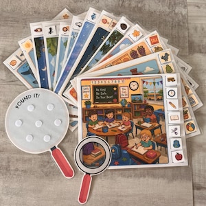 May include: A set of educational activity cards featuring colorful illustrations of classroom scenes and various objects. The set includes a circular white card with the text FOUND IT and a small magnifying glass cutout, both with red handles.
