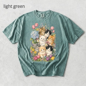 Puede incluir: Camiseta verde claro con una ilustraci&oacute;n floral de gatitos. El texto "light green" est&aacute; incluido. La camiseta tiene cuello redondo y mangas cortas. El dise&ntilde;o presenta varias flores y varios gatitos.