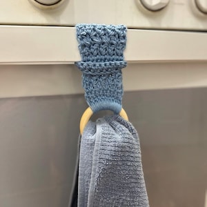 May include: A white ceramic mug with a black handle and the text "But First, Coffee" in a bold, black font. The mug is set against a neutral background, highlighting its simple design.