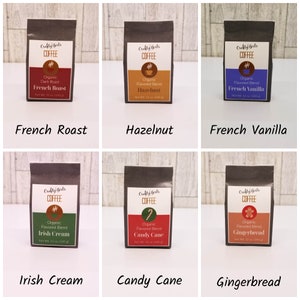 May include: Six brown paper bags with white text and images of coffee beans. Each bag features a different coffee flavor: French Roast, Hazelnut, French Vanilla, Irish Cream, Candy Cane, and Gingerbread.