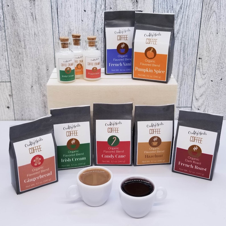 May include: Assortment of eight coffee bags and three small bottles of flavored creamer. The coffee bags are black with white text and feature various flavors, including gingerbread, Irish cream, candy cane, hazelnut, French vanilla, and pumpkin spice. The creamer bottles are clear glass with white labels and feature flavors like Irish cream, peppermint, and vanilla.
