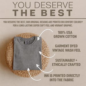 K&ouml;nnte beinhalten: Ein gefaltetes anthrazitfarbenes T-Shirt mit Rundhalsausschnitt. Der Text lautet: YOU DESERVE THE BEST. 100% USA GROWN COTTON, GARMENT DYED VINTAGE WASH FEEL, SUSTAINABLY + ETHICALLY CRAFTED, INK IS PRINTED DIRECTLY INTO THE FABRIC. Pfeile zeigen auf das T-Shirt.