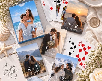 May include: A custom deck of playing cards featuring various couple photographs, initials, and the date 07.18.2026 printed on the box and individual cards. The set includes standard playing card faces and a card with the text A Brighter Together.