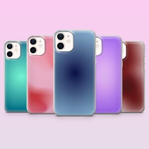 May include: Five colourful phone cases in teal, pink, blue, purple, and maroon. The cases have a clear border and are arranged in a row against a soft pink background. The phone cases are designed to fit a specific phone model.