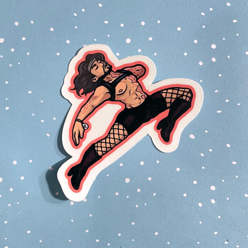 May include: A die-cut sticker featuring a stylized illustration of a person with long dark hair, wearing a black harness, black shorts, fishnet stockings, and black boots. The figure is posed in a dynamic, mid-air leap against a light blue background.