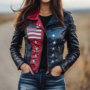 May include: Black leather jacket with a red collar and American flag design on the front. The jacket features white embroidered stars and a zipper closure. The jacket is worn with blue jeans.