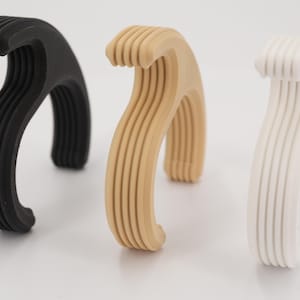 Può includere: Un set di tre tazze in ceramica con finitura opaca e macchiettata. Le tazze sono nei toni del crema, grigio chiaro e grigio scuro. Ogni tazza ha un design semplice e minimalista.