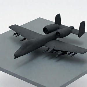 May include: A matte black model airplane with two engines and missiles under the wings. The aircraft is positioned on a gray square surface, set against a white background. The model has a detailed design.