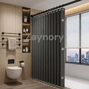 May include: A dark grey shower curtain with vertical pleats and silver grommets hanging from a black rod. The curtain features the text Zaynory printed across the fabric. The bathroom includes a wall-mounted toilet and a towel rack with a towel.