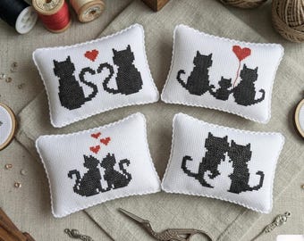 May include: Four rectangular white pincushions featuring black cross-stitched cat silhouettes and red heart motifs. The set includes sewing supplies like wooden spools of thread, balls of twine, embroidery hoops, and metal scissors.