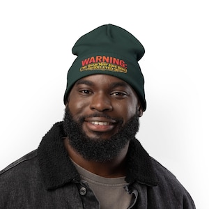 May include: A dark green beanie featuring the red text WARNING: and the gold text MY BRAIN MUST HAVE BEEN DELETED in a decorative font. The hat is a knit style with a cuffed edge, displaying the embroidered message clearly on the front center.