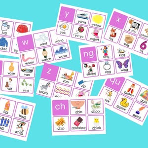 Puede incluir: Un conjunto de tarjetas didácticas con letras del alfabeto e imágenes asociadas. Cada tarjeta presenta una letra y varias imágenes, como "yate", "amarillo" y "yo-yo". Las tarjetas están dispuestas sobre un fondo azul claro.