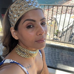 .	Relaxing beach shot highlighting the statement mirror work headband and jewelry ensemble