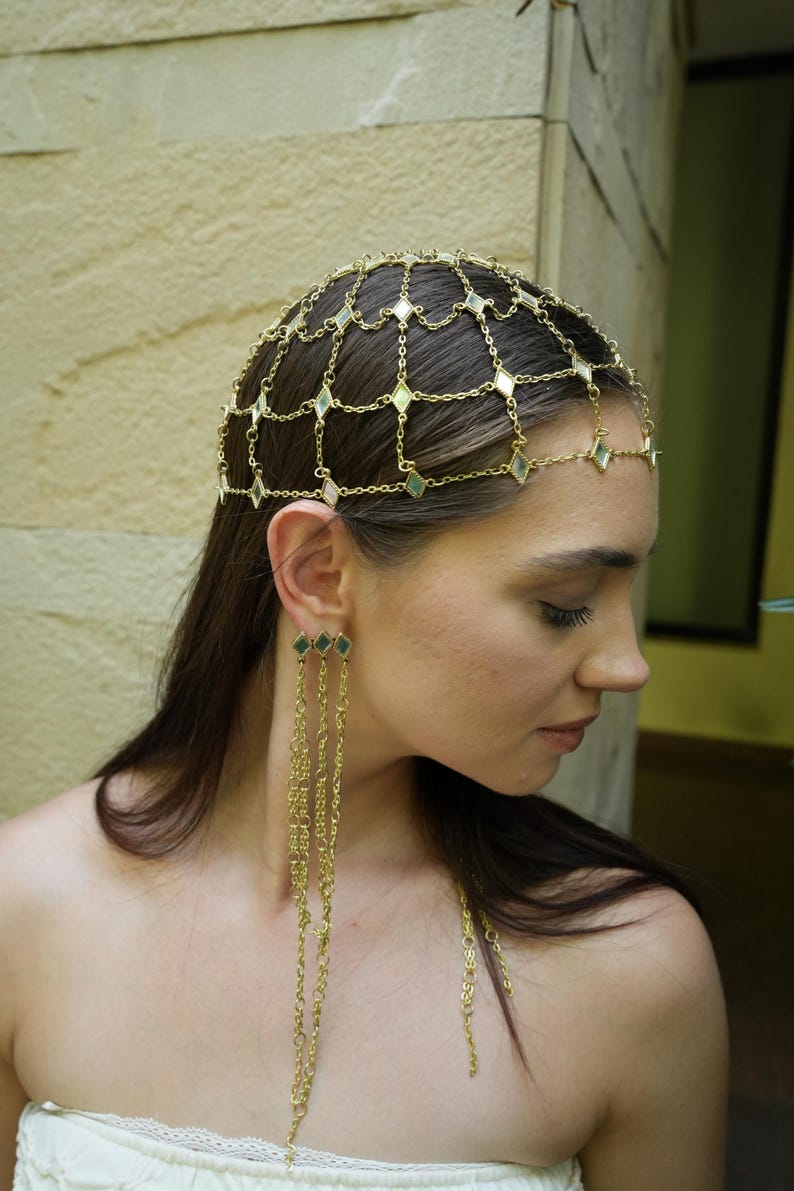festival ready gold hair chain crown with mirror embellishments and fluid chain earrings bold fashion styling  delicate gold lattice headpiece draped across scalp with matching multi chain earrings lightweight statement jewelry  editorial style gold head jewelry with structured chain pattern and long fringe earrings modern bohemian look  bridal hair chain accessory with geometric mirror shapes and flowing chain earrings soft romantic styling