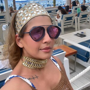 3.	Close-up of gold bangles and mirror work headband paired with chandelier earrings