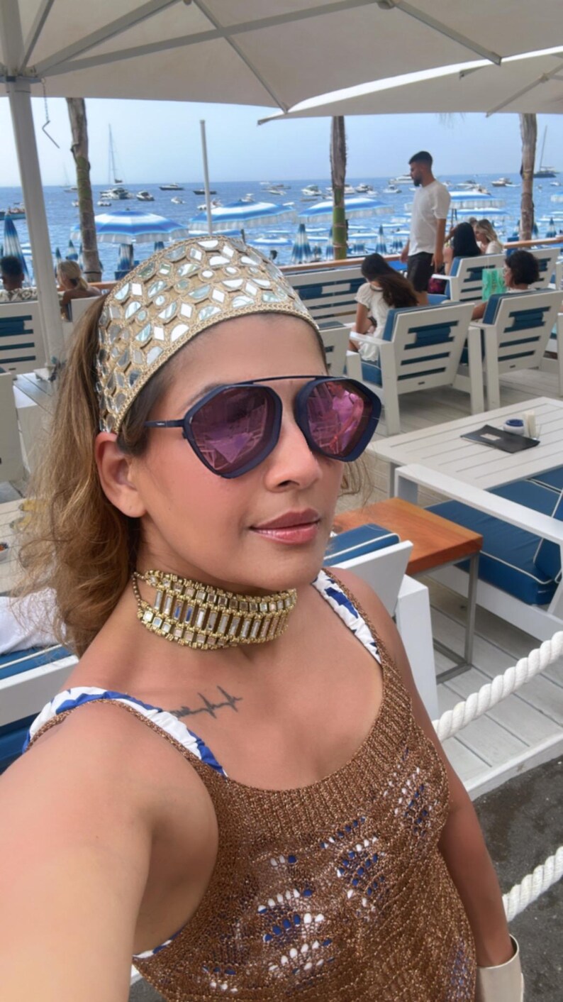 3.	Close-up of gold bangles and mirror work headband paired with chandelier earrings