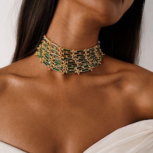 May include: A multi-strand choker necklace featuring horizontal rectangular green enamel or stone segments set within a gold-toned metal frame. The design consists of four interconnected rows of these green bars linked by small gold spheres.