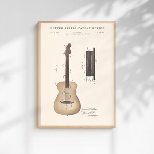 May include: A framed vintage patent print of a guitar. The print features a detailed illustration of a guitar and its bridge construction, with technical annotations and the text "United States Patent Office". The print is in a wooden frame.