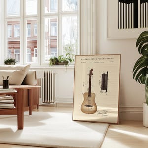 May include: A framed vintage patent print of a guitar, displayed in a bright, airy living room. The print features detailed diagrams and text from the United States Patent Office. The room includes a light-colored sofa, wooden coffee table, and a large potted plant.