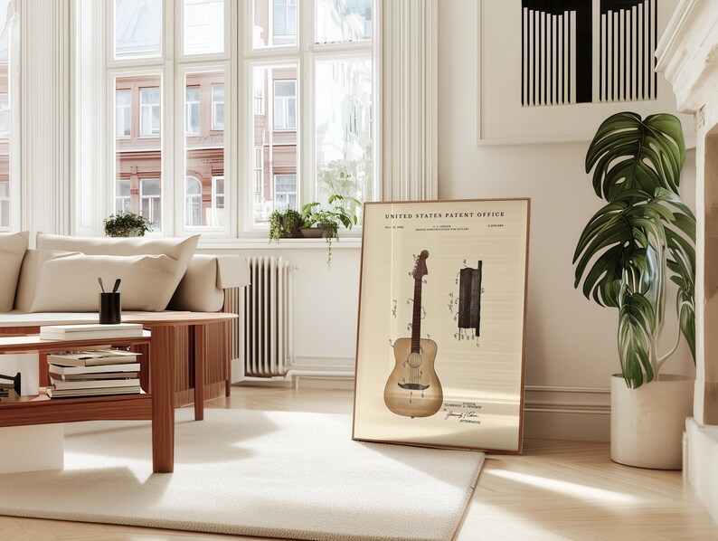 May include: A framed vintage patent print of a guitar, displayed in a bright, airy living room. The print features detailed diagrams and text from the United States Patent Office. The room includes a light-colored sofa, wooden coffee table, and a large potted plant.