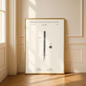 May include: A framed print featuring a United States Patent Office document for a L.E. Waterman fountain pen dated February 12, 1884. The print displays technical line drawings of the pen, including a side view and a cross-section, in black ink.