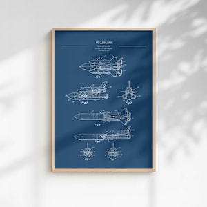 May include: A framed blueprint of a space vehicle, with white line drawings on a dark blue background. The print includes multiple views of the vehicle, labeled with figures and the text "US 3,866,863 Space Vehicle".