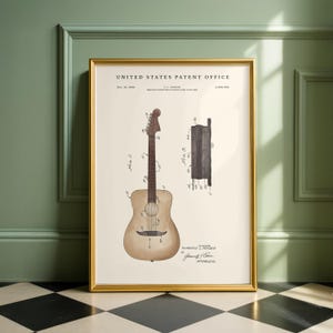 May include: Framed vintage patent print of a guitar. The print features a detailed illustration of a guitar and its bridge construction, with technical annotations. The print is in a gold frame and is displayed against a green wall.