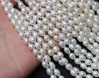May include: A strand of white oval-shaped freshwater pearls. The pearls are strung on a clear thread and are approximately 6-7mm in size. E Loose pearl.
