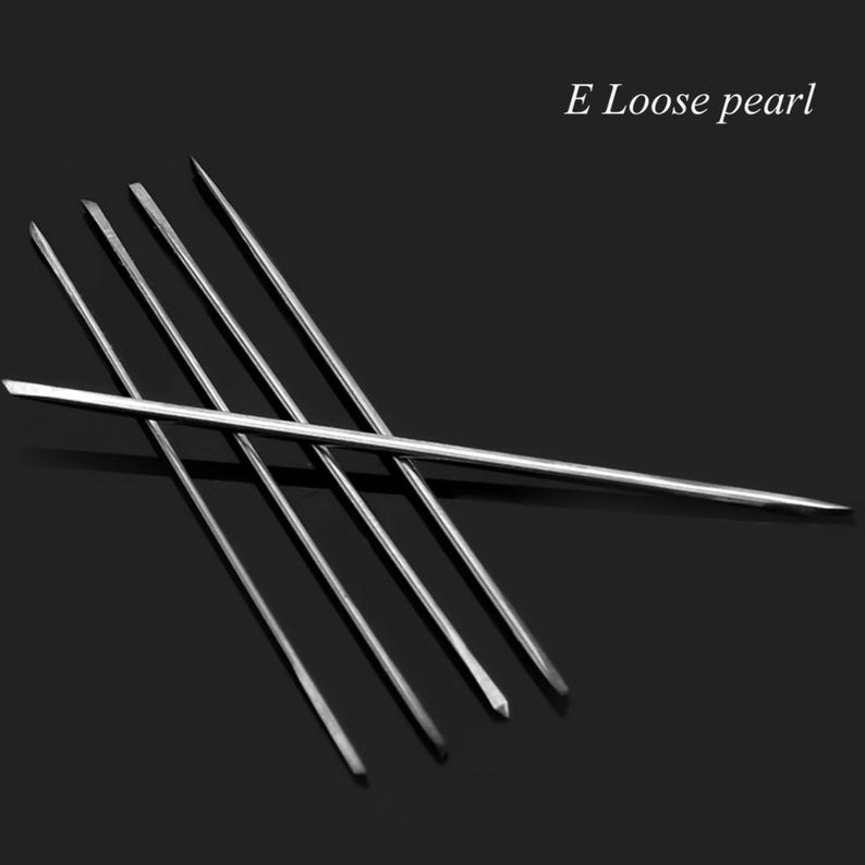 May include: Five silver metal tools, possibly for jewelry making, arranged in a criss-cross pattern on a black background. The text "E Loose pearl" is visible in the upper right corner of the image.
