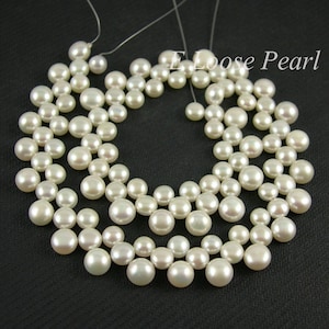 May include: A close-up of a white pearl necklace with multiple strands of pearls arranged in a circular pattern. The pearls are evenly spaced and create a delicate and elegant look.