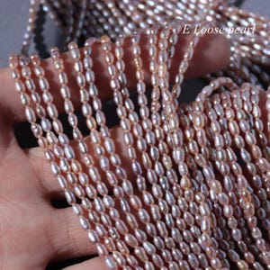 May include: Strands of oval-shaped pearls in shades of pink, peach, and white. The pearls are strung together, creating a textured and layered effect. The text "E Loose pearl" is visible in the upper right corner.