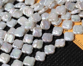 Peut inclure: Gros plan sur de nombreuses perles blanches de forme irrégulière. Les perles ont une forme carrée aux bords arrondis et un éclat nacré. Le texte "E Loose pearl" est visible. Les perles sont dispersées sur une surface sombre.