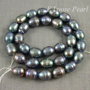 May include: A strand of dark gray oval-shaped pearls with iridescent shimmer. The pearls are strung on a white thread.