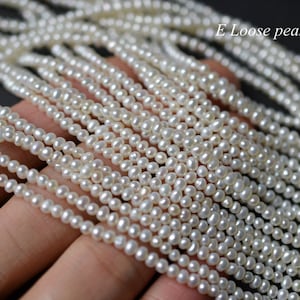 May include: A strand of white freshwater pearls, shown as loose pearls, for jewelry making.