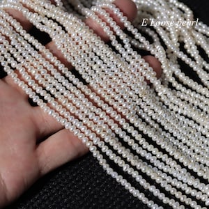 Może przedstawiać: Pasemka małych, białych pereł. Perły są nawleczone, tworząc wiele rzędów koralików. Obraz jest dobrze oświetlony, ukazując połysk pereł. Tekst w prawym górnym rogu brzmi "E Loose pearl."