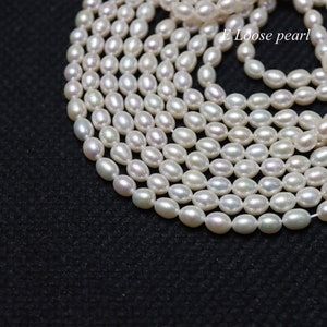 May include: A close-up shot of a collection of oval-shaped, off-white pearls. The pearls are strung together, creating a layered effect against a dark background. The text "E Loose pearl" is visible in the upper right corner.