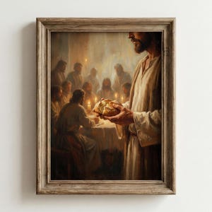 May include: A framed print depicting a religious scene. The artwork shows a figure holding bread, with a group of people seated around a table in the background. The painting has a warm color palette and is set in a dimly lit room.